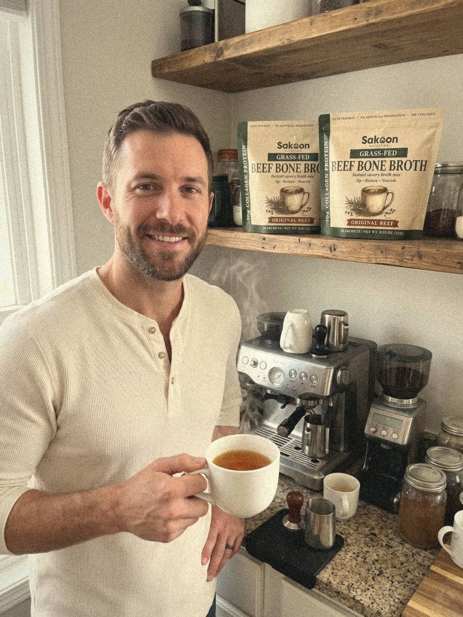 Man at his coffee station with a mug of broth and Sakoon pouches on the shelf