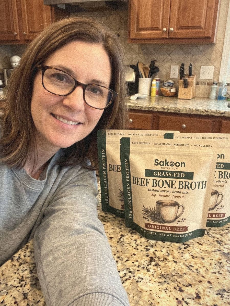 Woman leaning into a selfie with Sakoon pouches lined up on her counter